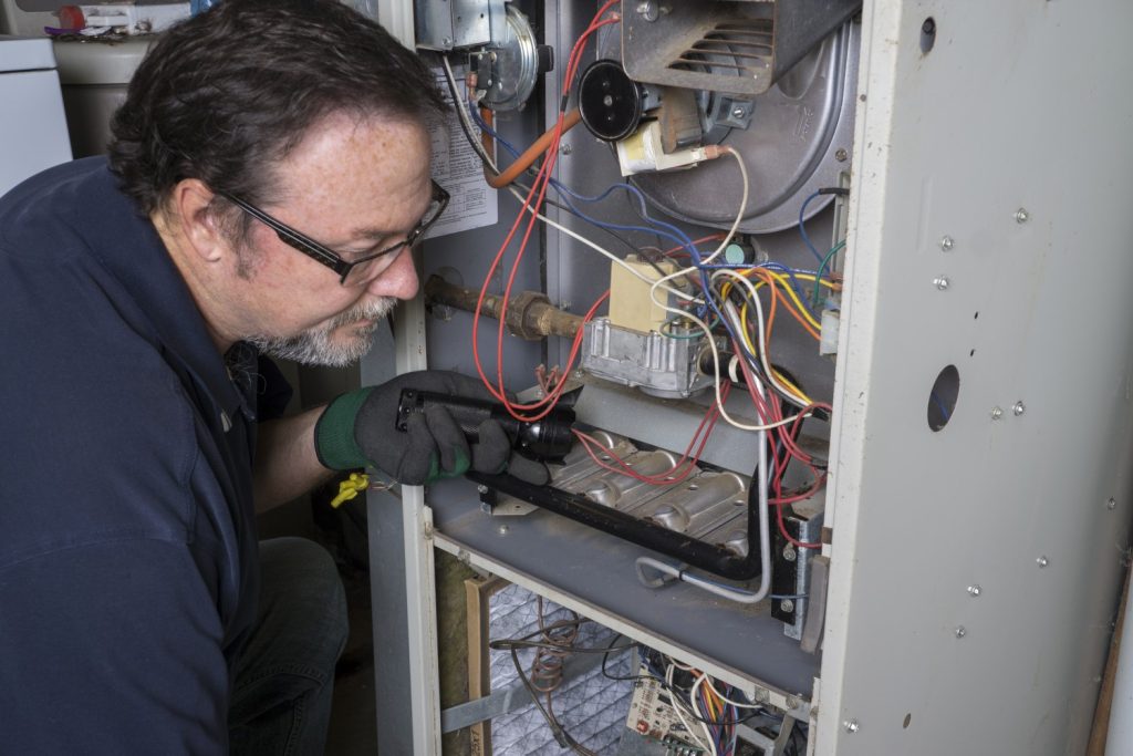  Heating Technician Installation Over A Gas Furnace